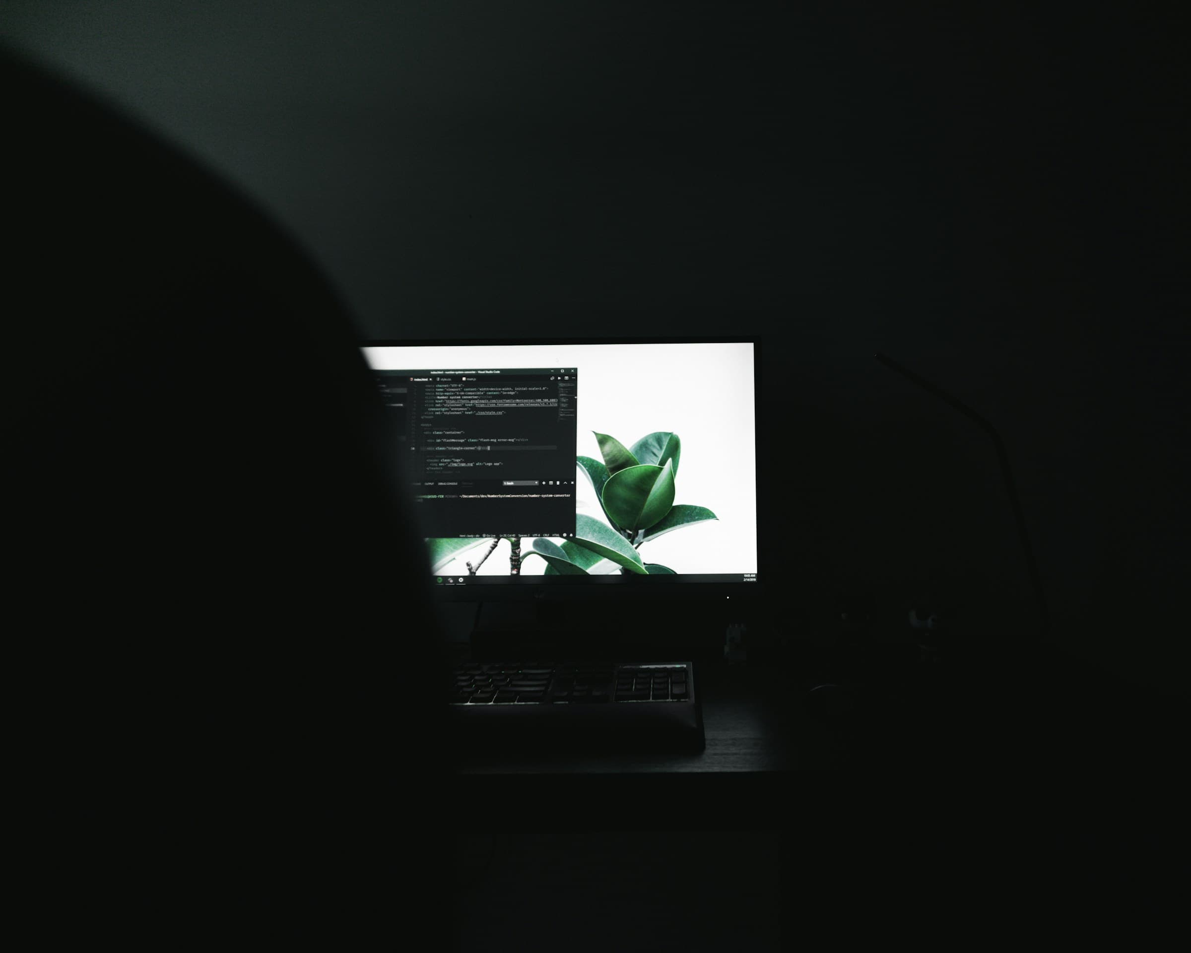 Écran allumé dans une pièce plongée dans le noir, éditeur de code au premier plan